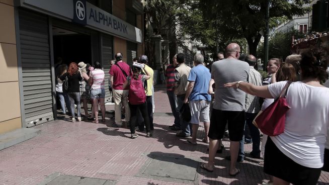 <b>BANK RUN:</b> Grekerne har stått i lange køer for å ta ut cash i helgen, i påvente av bankkrise. Her ser vi en lang kø foran en av Alpha Banks minibanker i Athen søndag.